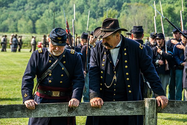 Two officers standing at the fence discussing battle strategy. 