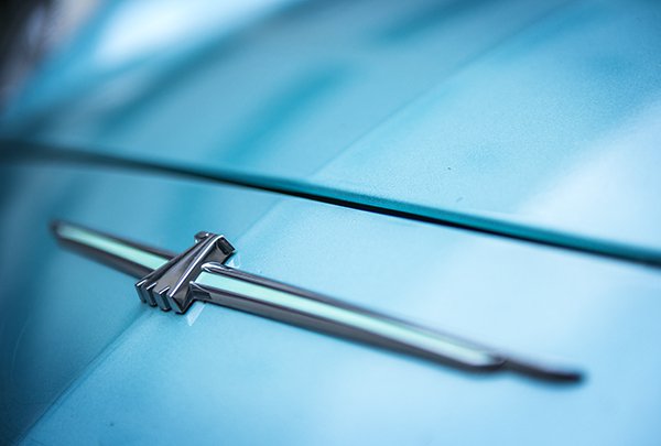 This badge on the hood of a car was taken at 70mm and handheld. The clarity and sharpness is good and the close up shot isolates the badge